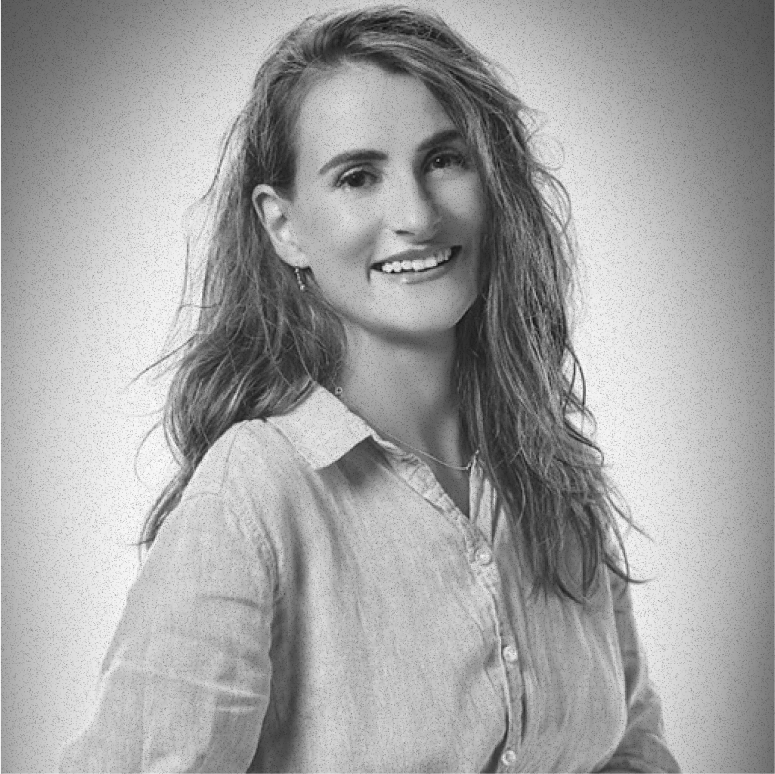 Black and white portrait of a smiling woman with long wavy hair wearing a button-up shirt.